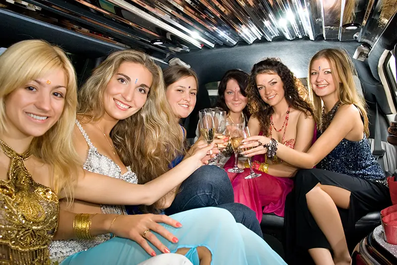 Women with wine glasses in a limousine